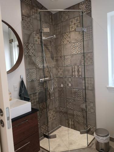 a shower with a glass door in a bathroom at Løkken City Apartment in Løkken