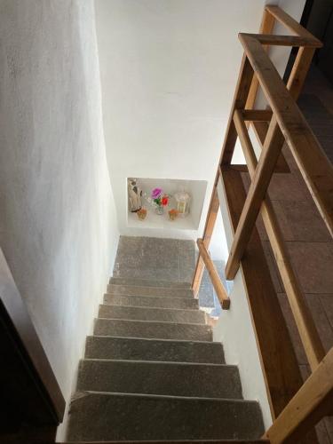 a stairway leading up to a white room with wooden stairs at THE DORMOUSE - Il Ghiro in Reusa