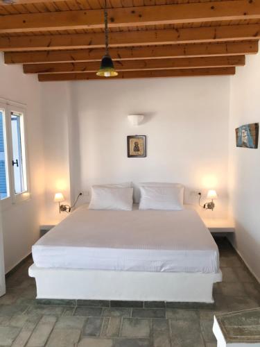 a bedroom with a white bed with two pillows at The Aegean Horizon Villa in Grótta