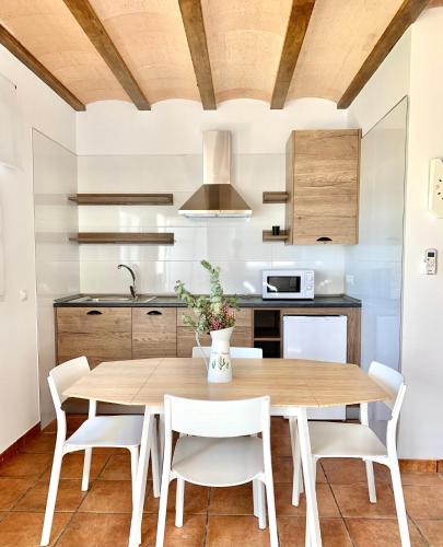 a kitchen with a wooden table and white chairs at ALAMANCHA in Casas de los Pinos