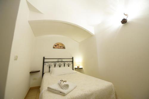 a bedroom with a bed with two towels on it at Antica Aia B&B in Cisternino