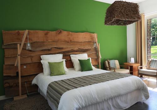 a bedroom with a large bed with green walls at Domaine de Fresnoy in Loison-sur-Créquoise