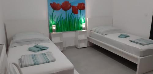 a room with two beds and a painting of red tulips at Hannas Paradise - Villa Evi in Skafidia