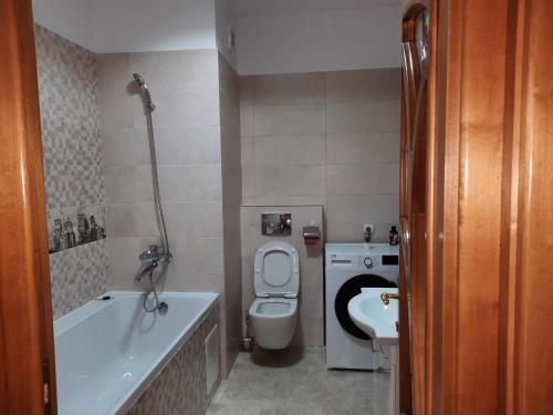 uma casa de banho com um WC, uma banheira e um lavatório. em Jeni' s apartament em Constança