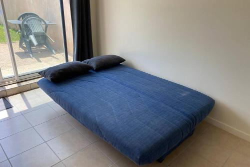 a blue bed with two pillows on top of it at Loft 21 m² pouvant accueillir 4 personnes in Monteux