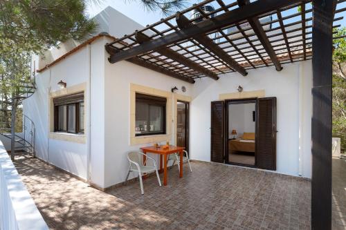a patio with a table and a pergola at Villas Alexandros in Kalamaki
