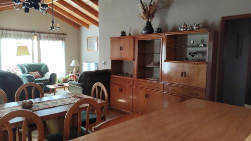 una sala de estar con un armario de madera y una mesa.  en Casa CAVOK en San Carlos de Bariloche