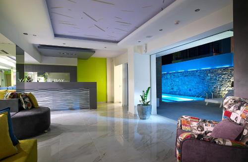 a lobby with two couches and a swimming pool at Mistral Bay Hotel in Agios Nikolaos