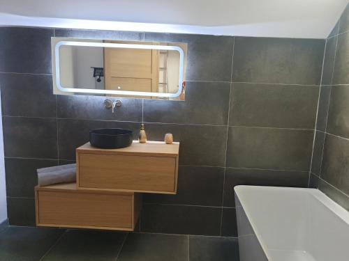 ein Bad mit einem Waschbecken und einem Spiegel in der Unterkunft Charmante Maison La Source in Grandes Sables