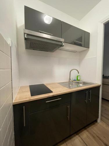 une cuisine avec un évier et une cuisinière dans l'établissement Studio front de mer - Menton Garavan, à Menton