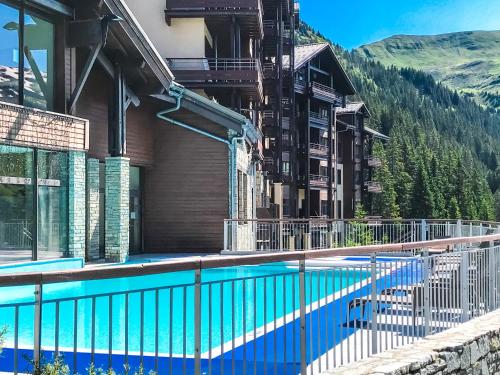 - une piscine en face d'un bâtiment avec une montagne dans l'établissement South-facing newly renovated 2-bed apartment Les Terrasses d'Eos, à Flaine