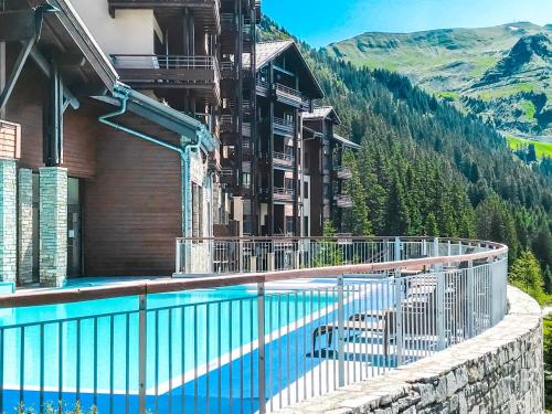 un hôtel avec une piscine en face d'une montagne dans l'établissement Bright, spacious South-facing 1-bedroom apartment, à Flaine
