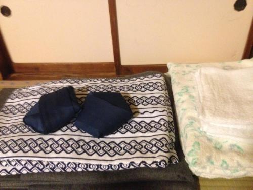 two blue pillows sitting on top of a blanket at Chuokan Shimizuya Ryokan in Nagano