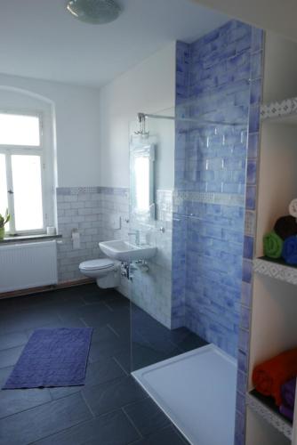 La salle de bains est pourvue d'un lavabo, de toilettes et d'une douche. dans l'établissement Ferienwohnung ANDERE ZEITEN, à Frankenberg