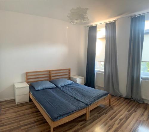 una camera da letto con un letto con lenzuola blu e una finestra di Kamienica2 a Chorzów