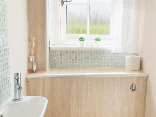 baño con lavabo y ventana en Shepherd's Cottage, en Bridlington