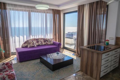 a living room with a purple couch and a large window at Golden Apartments in Ulcinj