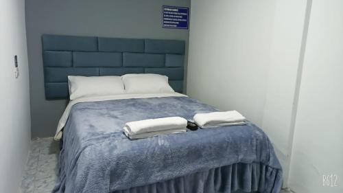 uma cama com duas toalhas em cima em Hostal Da`Silva em Quito