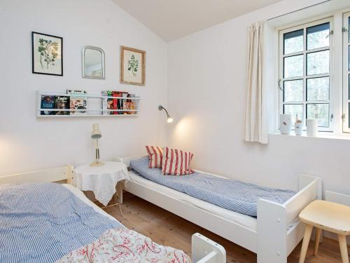 Schlafzimmer mit einem Bett, einem Tisch und einem Fenster in der Unterkunft Holiday home Fårevejle XII in Fårevejle