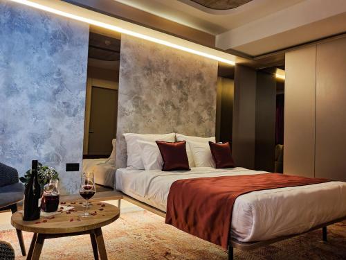 a bedroom with a bed and a table with wine glasses at Hotel City Code in Zenica