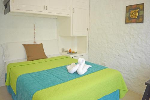 a white teddy bear sitting on top of a bed at Hostal Cann's House in Puerto Baquerizo Moreno