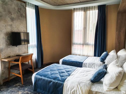 a hotel room with two beds and a television at Hotel City Code in Zenica