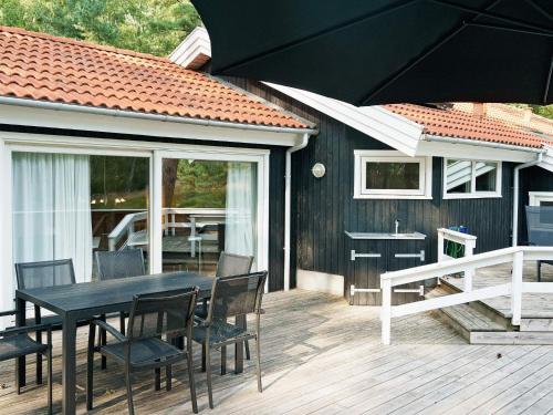 Vester Sømarkenにある10 person holiday home in Nexの木製デッキ(黒いテーブルと椅子付)