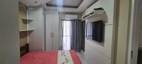 a small room with a bed and a window at Apartamento em Caraguatatuba em Frente a Praia in Caraguatatuba