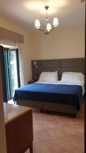 a bedroom with a large bed with a blue blanket at Residence l'Incanto in Piano di Sorrento