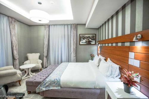 a hotel room with a bed and a chair at Charleson Luxury Hotel in Port Harcourt