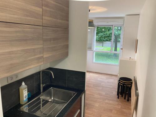 une cuisine avec un évier et un plan de travail dans l'établissement Studio Zen - Shopping center and train station 500m - Disneyland Paris 5min, à Montévrain