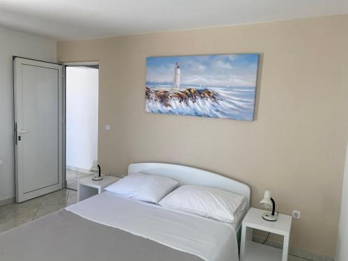 1 dormitorio con 1 cama y una foto de un faro en Apartmani Leona, en Bibinje