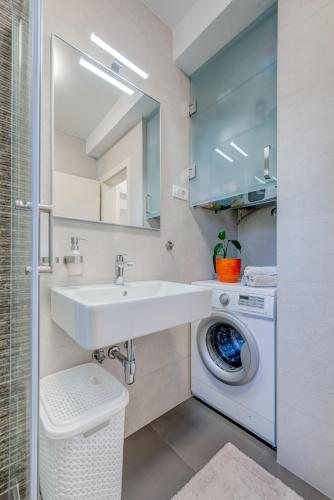 a bathroom with a sink and a washing machine at Chris's condo 2 in Split