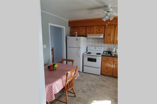 cocina con mesa y nevera blanca en Ocean Front House in Cook's Harbour Newfoundland, en Raleigh