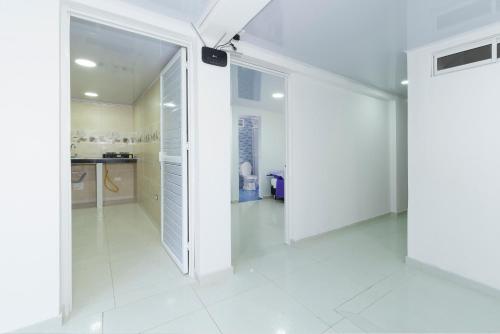 um corredor com paredes brancas e pisos em azulejo branco em La isla inn em San Andrés