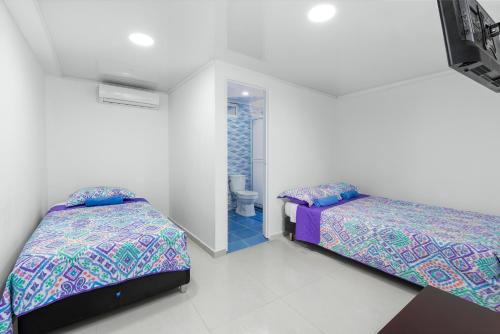 a bedroom with two beds and a bathroom at La isla inn in San Andrés