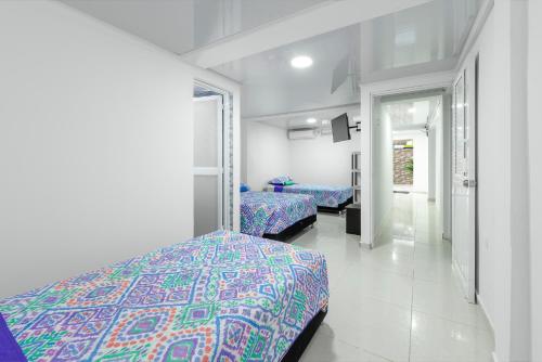 a bedroom with two beds and a hallway at La isla inn in San Andrés