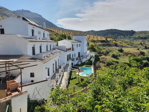 eine Reihe von weißen Gebäuden mit einem Pool in der Unterkunft La Luna del sur B&B in Granada