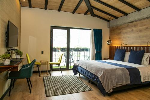a bedroom with a bed and a desk and a table and chairs at Viajero Bogota Hostel & Spa in Bogotá