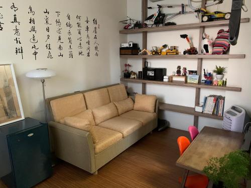 sala de estar con sofá y mesa en 幸福客棧 en Ho-mei