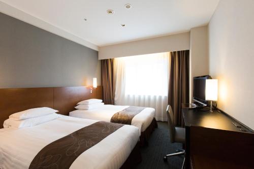 Postel nebo postele na pokoji v ubytování Hakata Excel Hotel Tokyu