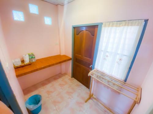 ein kleines Bad mit einer Tür und einem Fenster in der Unterkunft BaanChomJan @ Suanphung in Suan Phung