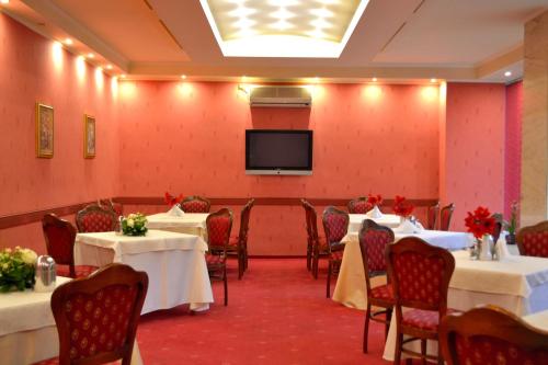 a banquet room with tables and a flat screen tv at Hotel Tiara in Ploieşti