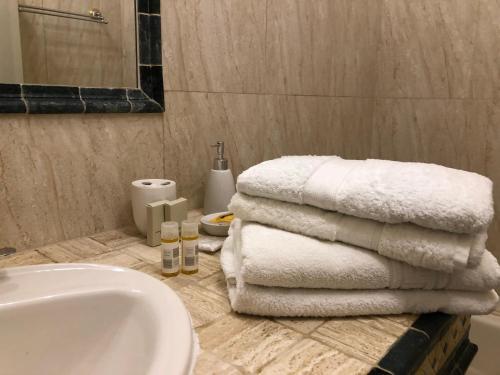 - une salle de bains avec un tas de serviettes sur un comptoir dans l'établissement Lyon 3 Triangle d'Or, à Lyon