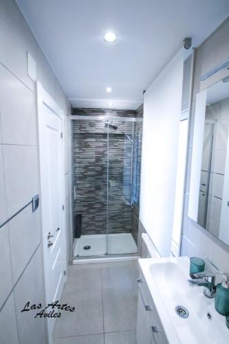 a bathroom with a shower and a sink and a mirror at Piso las Artes in Avilés