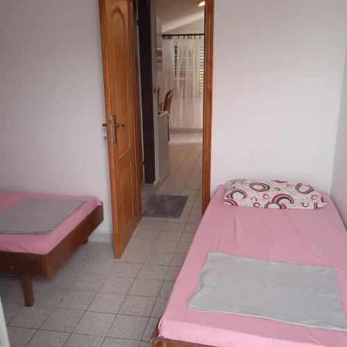 una camera con due letti e una porta per un corridoio di Apartmani Dotlić a Njivice