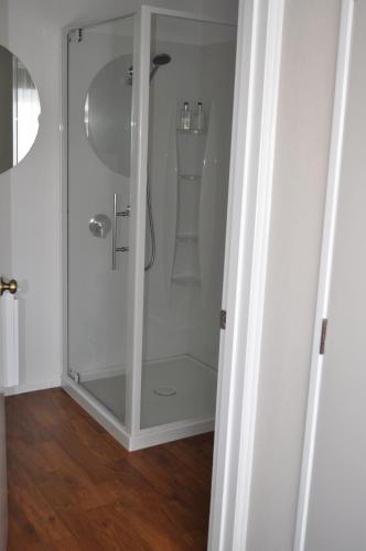 a shower with a glass door in a bathroom at Carramar Motor Inn in Palmerston North