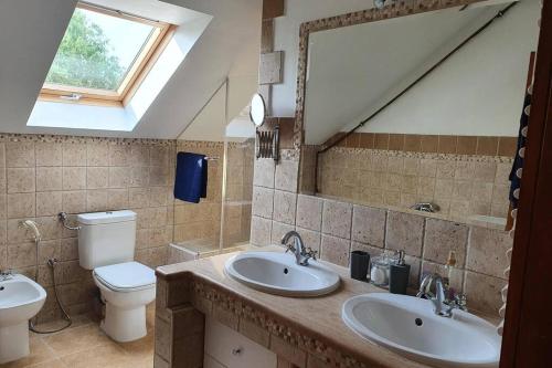 uma casa de banho com 2 lavatórios e um WC em Villa Tátika em Gárdony