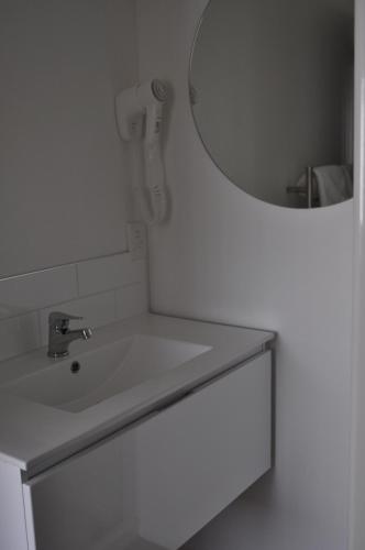 a bathroom with a sink and a mirror at Carramar Motor Inn in Palmerston North