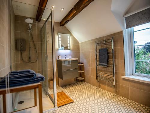uma casa de banho com um chuveiro e um lavatório. em Eleri Cottage em Great Malvern